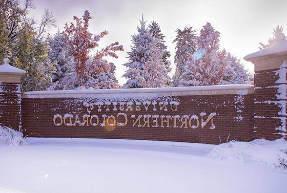 University of Northern Colorado brick sign covered in a dusting of snow.